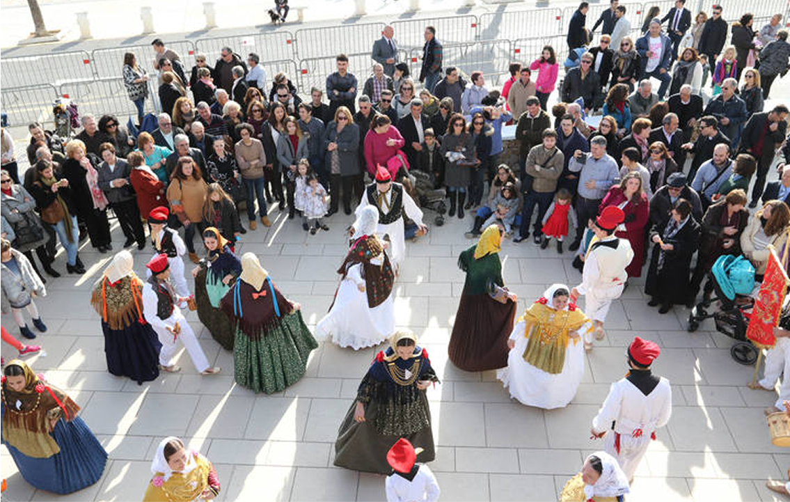 Hombres y mujeres bailan al ritmo del tambor, flauta y castañuelas ataviados con la vestimenta y joyería tradicional.